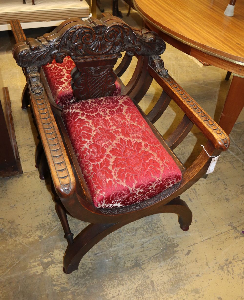 A set of four early 20th century carved oak X-frame chairs, W.61cm, D.58cm, H.76cm